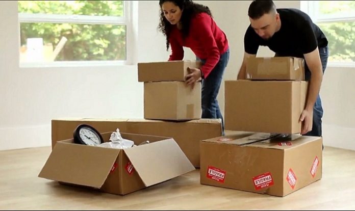 couple qui remplit cartons de demenagement